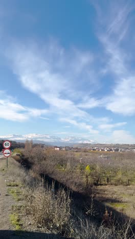 vertical shot of leafless orchards, distant town, and hills under blue sky near quba. quba, azerbaijan
