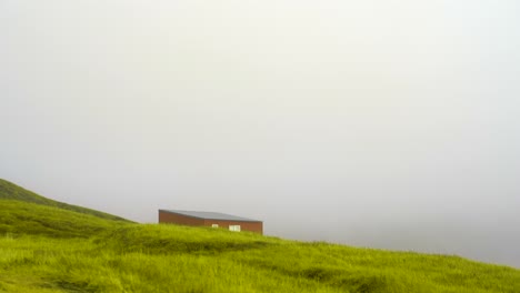 Picturesque-Red-Cabin-lonely,-Lush-Green-Field-on-Iceland-Highlands