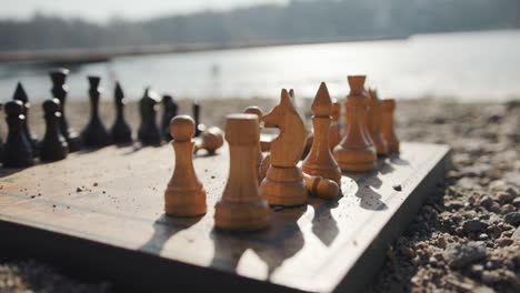 antique chessboard on sand beach by the water, slow motion artistic shot