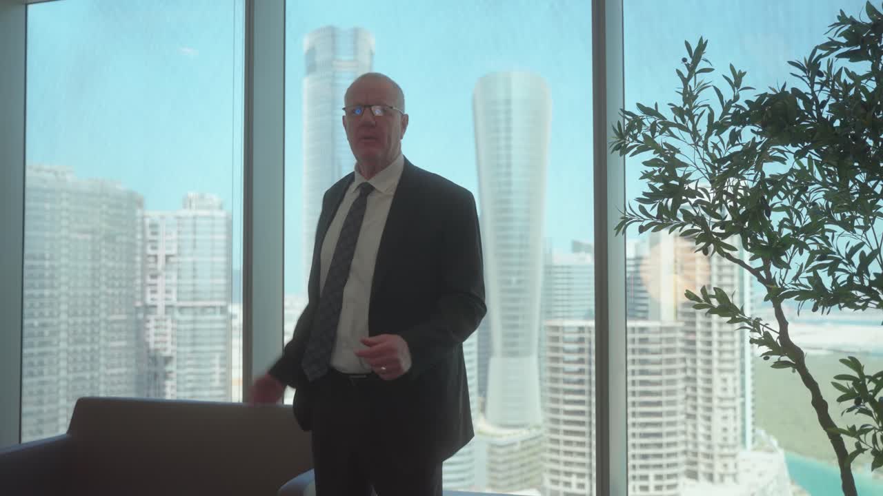 Upset, angry, senior or older businessman screaming at someone in an office - slow motion skyscraper city view