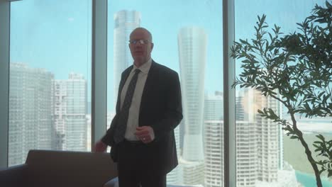 upset, angry, senior or older businessman screaming at someone in an office - slow motion skyscraper city view