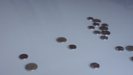 a hand sweeping coins off a table