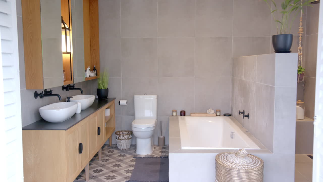 Modern bathroom with double sinks, bathtub, and stylish decor in single male home, copy space