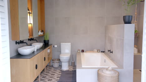 modern bathroom with double sinks, bathtub, and stylish decor in single male home, copy space