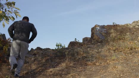 man running up a rocky hill