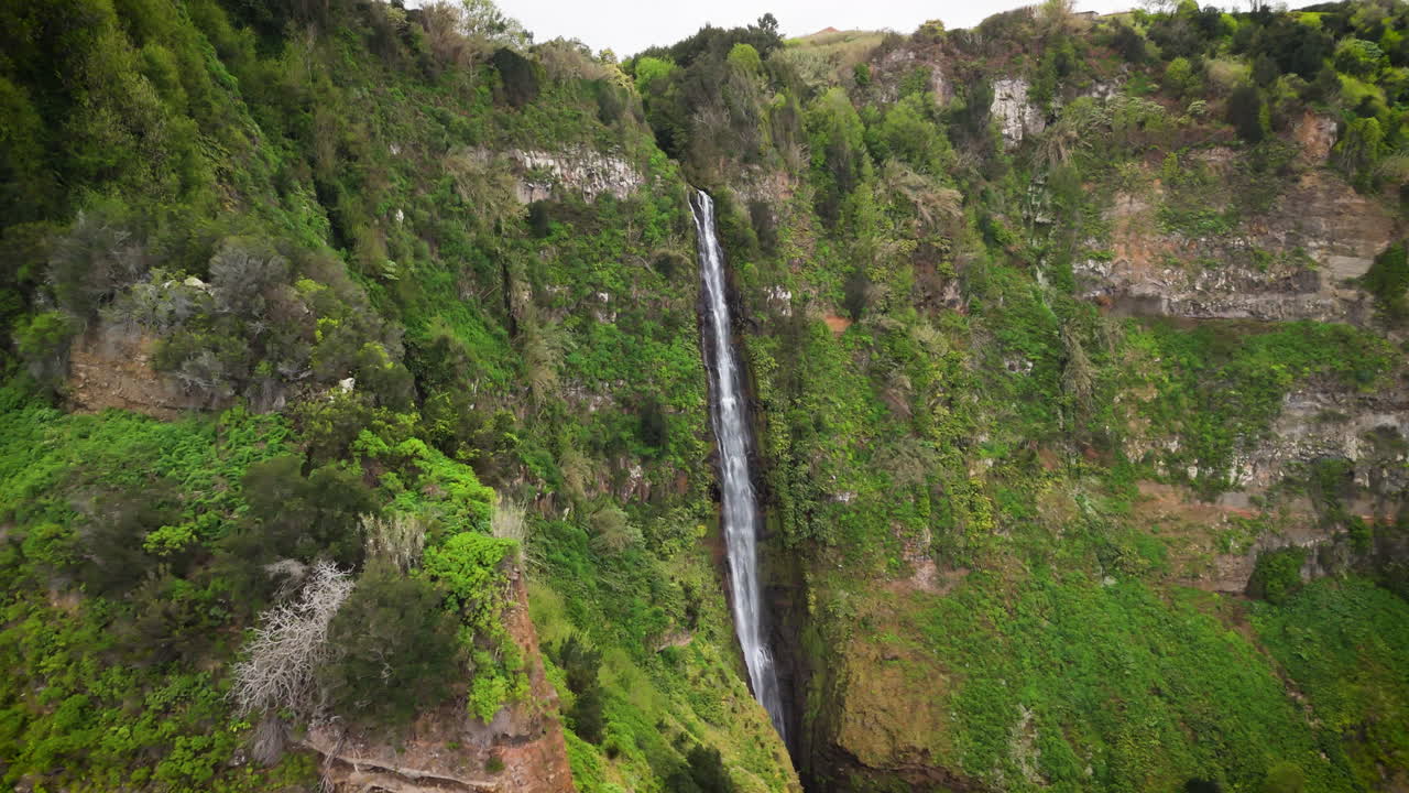 volando hacia una cascada en las montañas verdes, rocha do navio, madeira, portugal