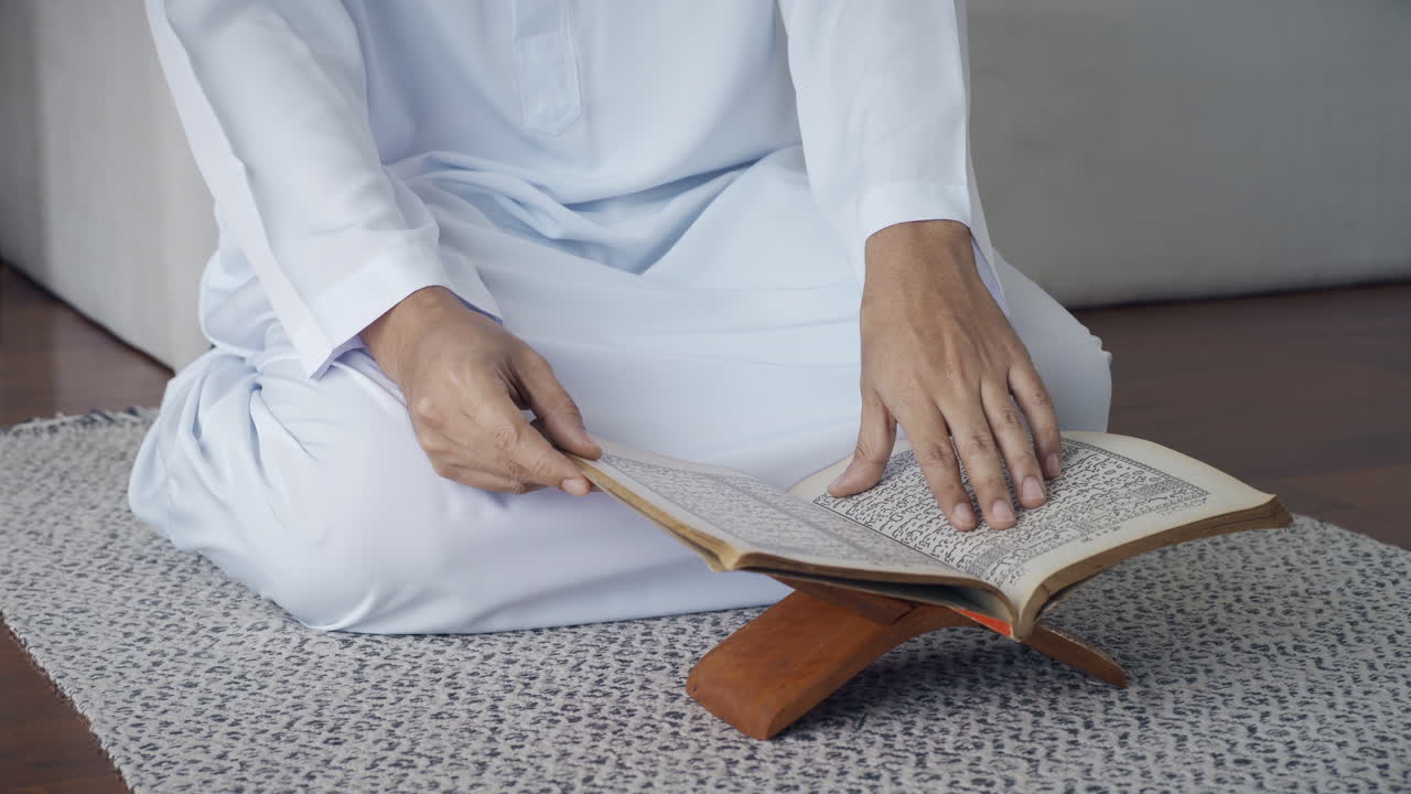 Asian Muslim man reciting surah al-Fatiha passage of the Qur'an, in a daily prayer at home in a single act of sujud called a sajdah or prostration