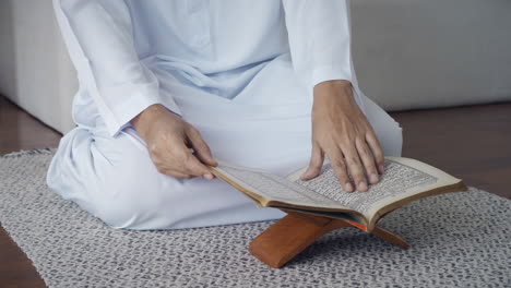 asian muslim man reciting surah al-fatiha passage of the qur'an, in a daily prayer at home in a single act of sujud called a sajdah or prostration