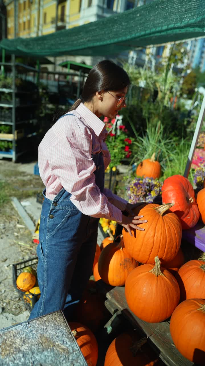 mujer recogiendo calabazas en un mercado de otoño