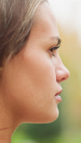 portrait view of lady's face with visible goosebumps all over, emotional reaction to cold or excitement, natural skin, close-up expression, soft lighting, calm and serene outdoor shot