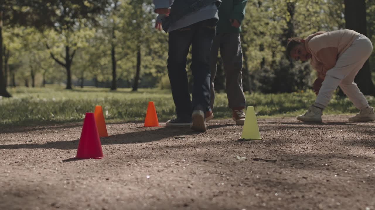 Children playing outside with cones in a park