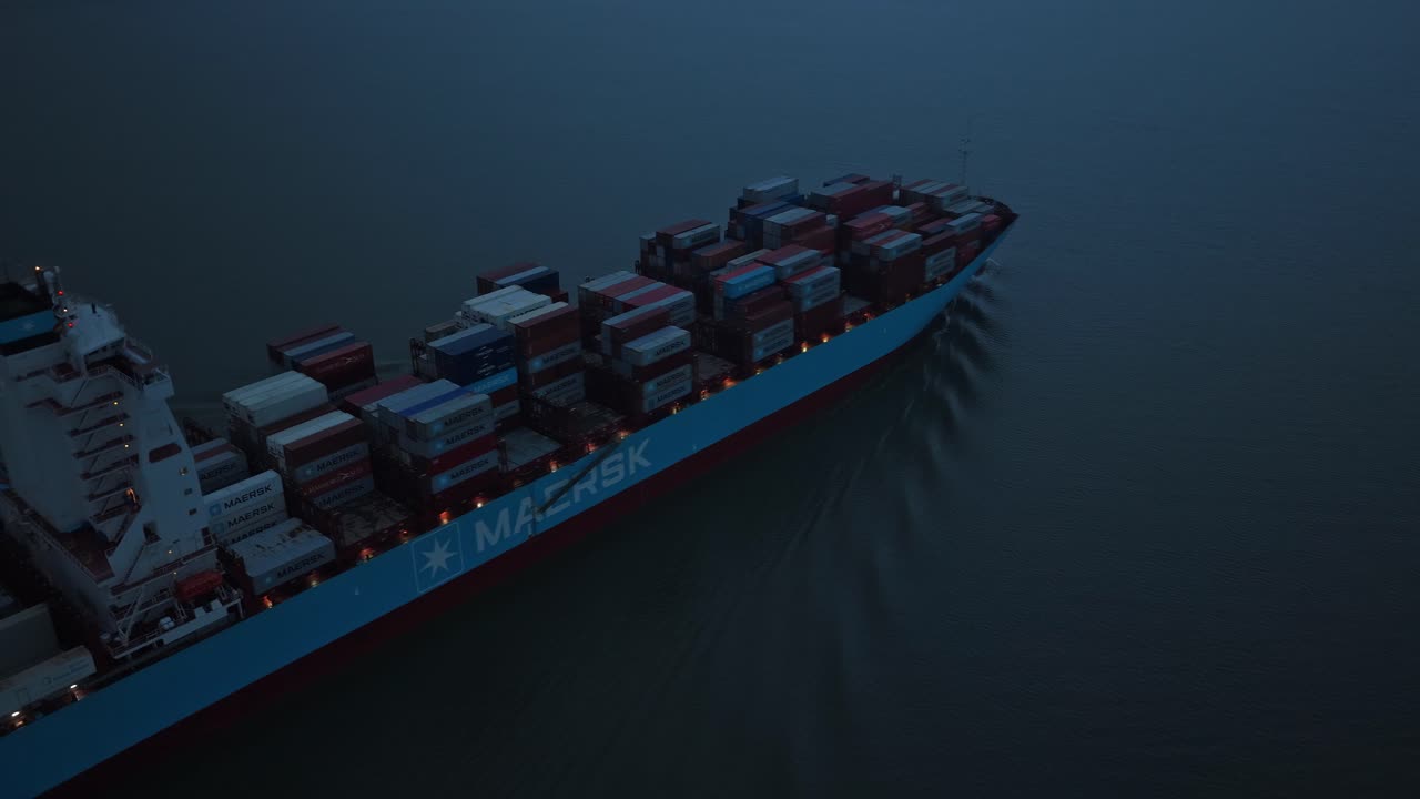 Logistics vessel navigates Elbe River in tranquil evening light