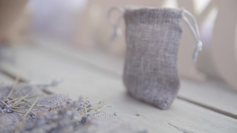 Female-hand-puts-a-bouquet-of-lavender-on-a-wooden-table