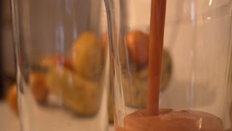 close-up of an healthy tropical fruit juice that pours into glass