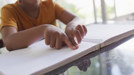 video de la sección media de un niño ciego afroamericano leyendo en braille