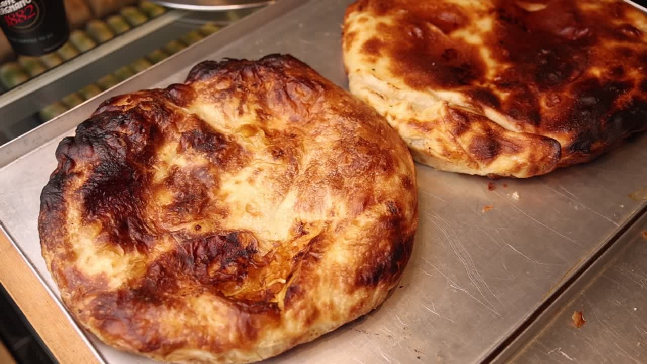 Burek appena sfornati e dorati su un vassoio di metallo