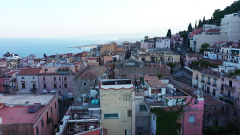 rising above the buildings to reveal beautiful landscape of an old italian city with the mediterranean sea in the background. taormina, sicily