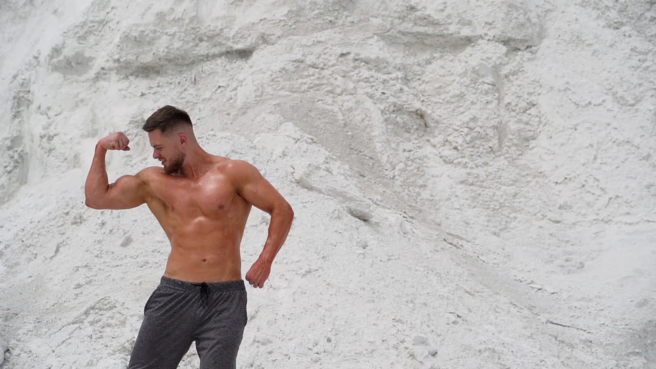 Uomo muscoloso in posa su una montagna. Uomo muscoloso con un corpo perfetto in posa su una montagna.