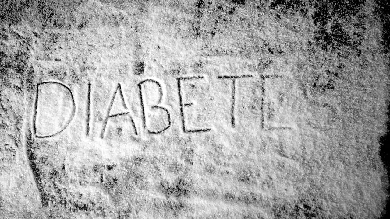Diabete scritto in polvere di zucchero che viene soffiata via
