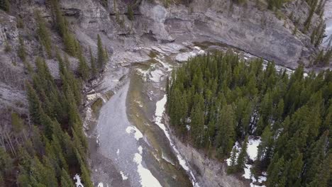 static aerial view of a boreal river canyon in spring