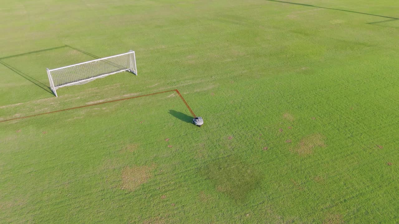 A robot autonomously paints lines on a soccer field, showcasing precision and efficiency in an outdoor setting