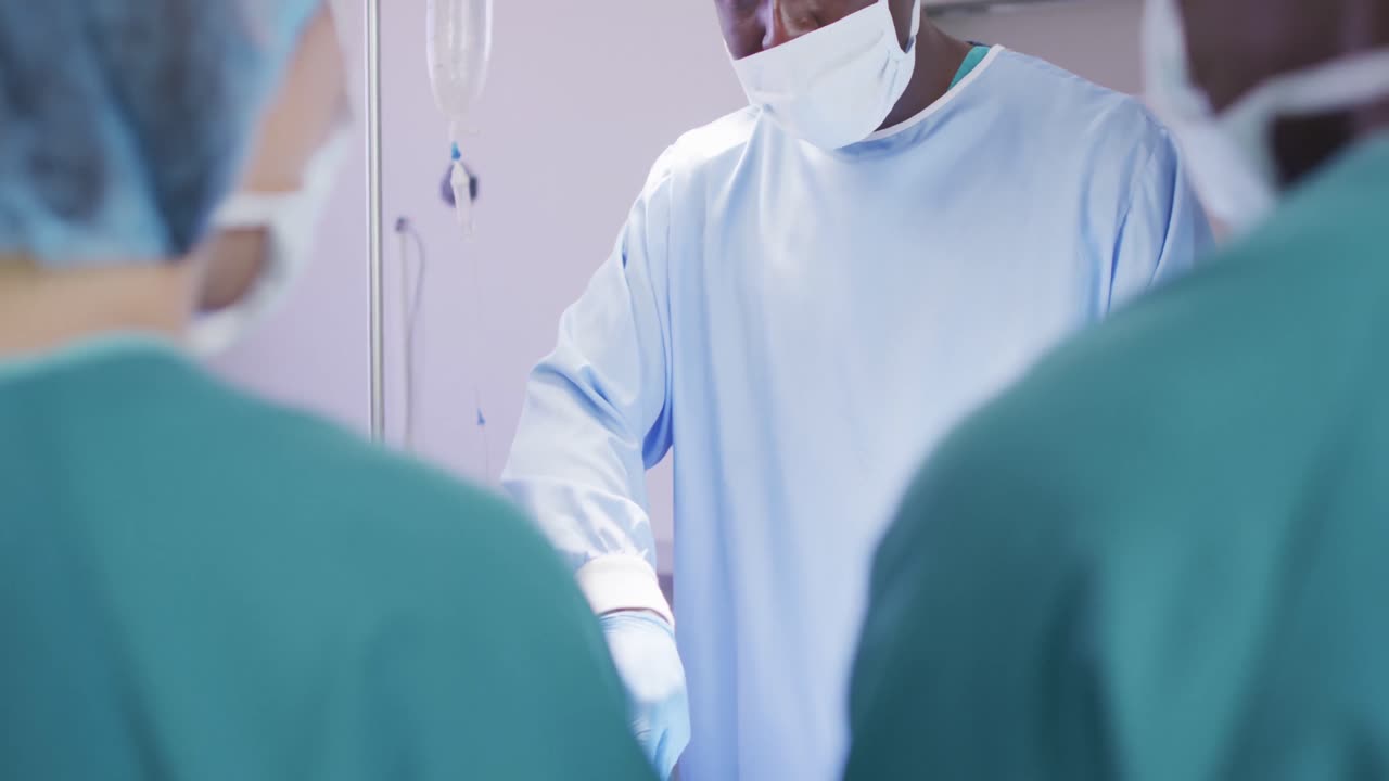 video de un cirujano afroamericano hablando con varios colegas durante una operación en el teatro