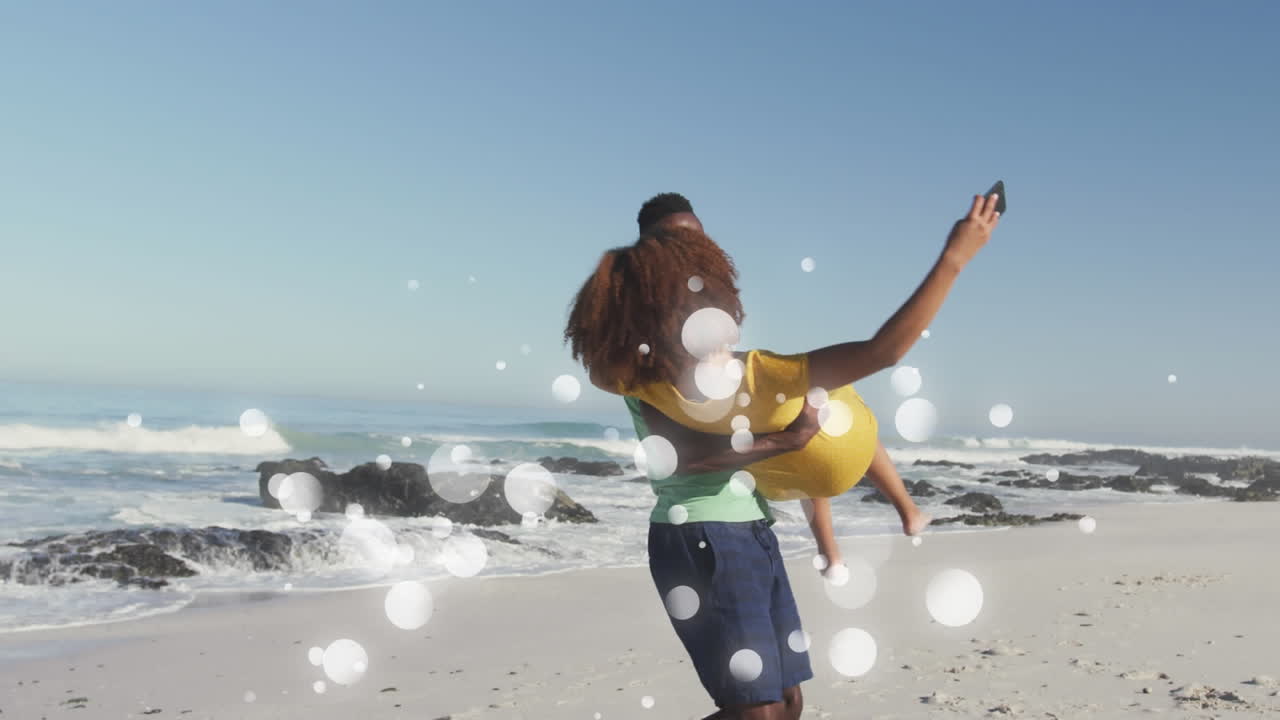 animación de una feliz pareja afroamericana divirtiéndose en la playa usando un teléfono inteligente, sobre manchas blancas