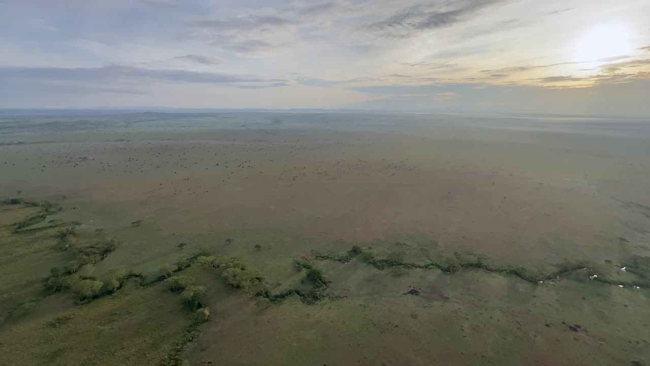 una vista aérea temprano en la mañana de las llanuras del serengeti, con un pequeño río en primer plano. tanzania.