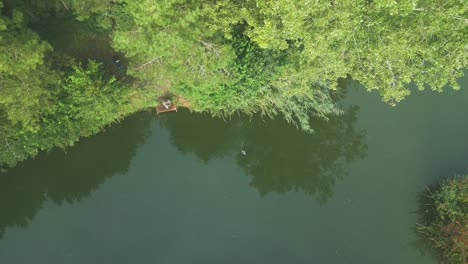 Vista-Aérea-De-Un-Lago-Tranquilo-Con-Reflejos-Durante-La-Mañana-Brumosa