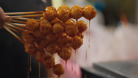grilled meatballs on skewers, dripping sauce
