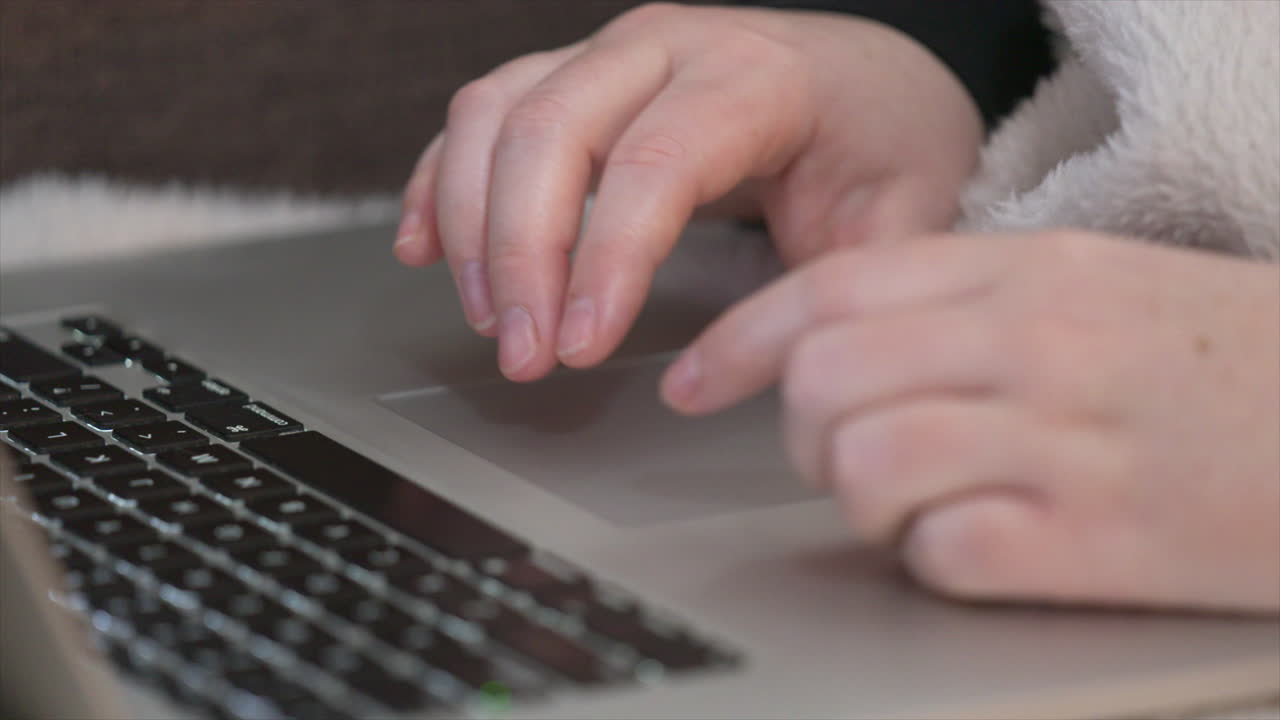 manos usando el panel táctil de la computadora portátil mientras trabaja desde casa