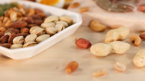 A variety of nuts and seeds displayed on a wooden table, highlighting their textures and colors.