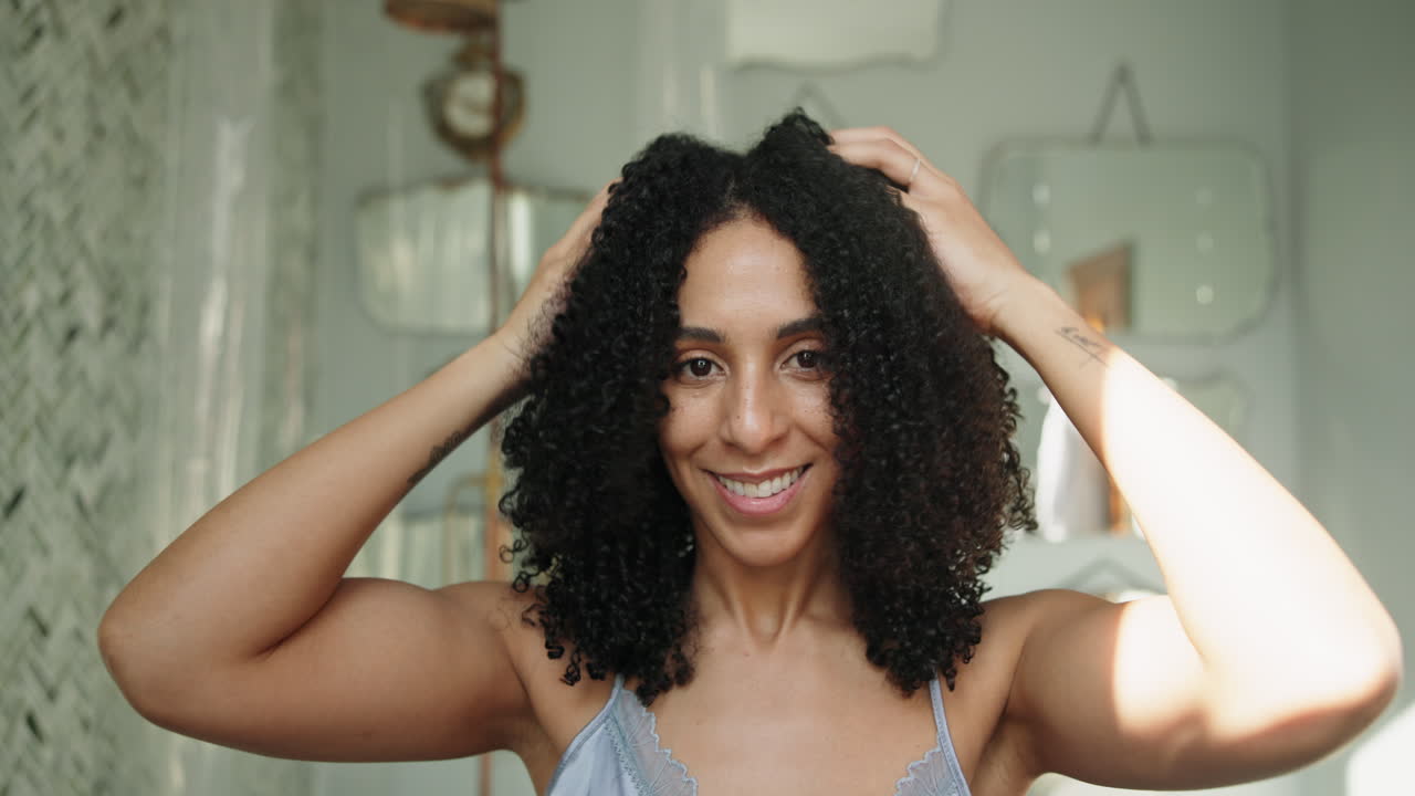 Young Woman Touching and Styling Her Natural Curly Hair