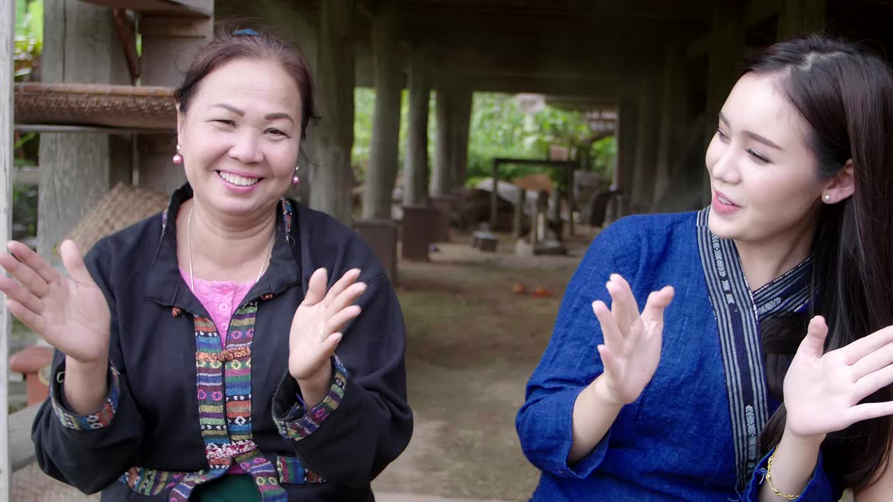 Two Women Sharing a Conversation in a Traditional Thai Setting