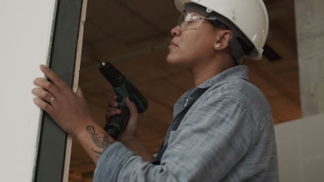 biracial worker using drill