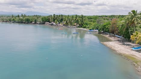 fishing boats on the tranquil ocean of playa palenque in san cristobal, dominican republic - drone shot