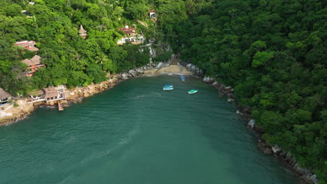 Flying-around-boats-at-a-secret-beach-in-Puerto-Vallarta,-Mexico---Aerial-view