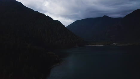 silhouette of mountain and forest at blue hour along treeline edge, aerial dolly