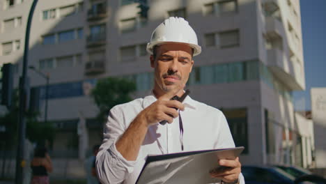 serious architect dictate instructions using portable radio at street closeup