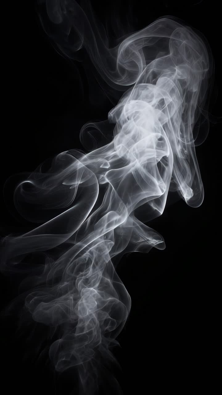 Un video ipnotico ravvicinato di fumo che turbina su uno sfondo nero, ripreso da un’angolazione della camera bassa