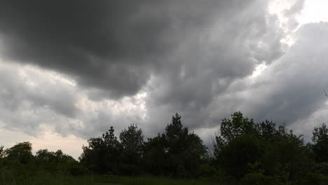 time lapse of thick dark clouds moving over silhouette of trees