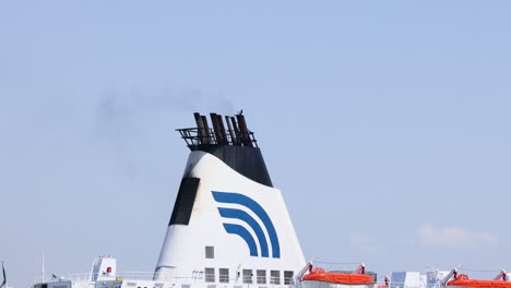 transbordador que sale del puerto con rastro de humo