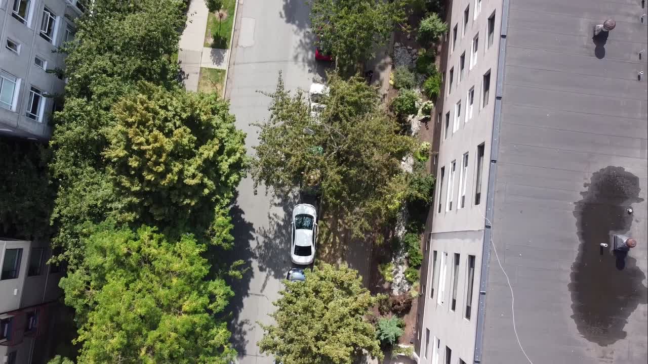 2-3BEV Aerial birds eye view 200 feet over low rise detached homes apartments quiet residential community to retail backs with hardly any people out walking shopping on a sunny day with lush trees