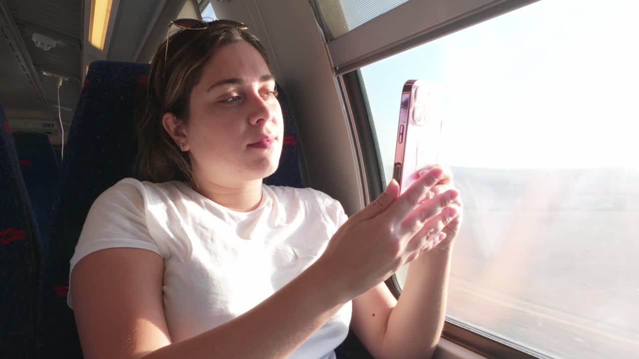 Woman Taking a Photograph of the View from a Train Window