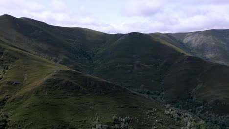 Aerial-drone-footage-of-lush-mountain-range-on-a-cloudy-day