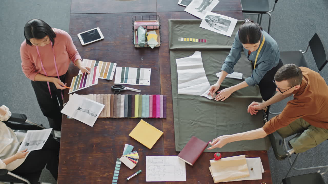Slowmo Top View of Fashion Designers Working on Garments