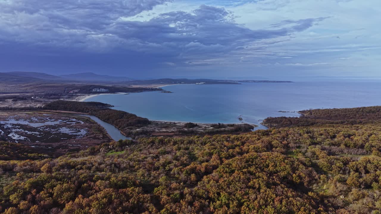 Vast coastal view with river and beach surrounded by greenery