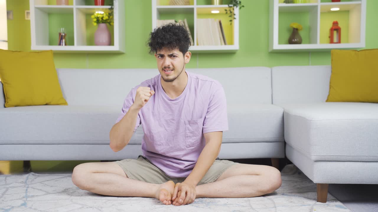 젊은이가 엄격하고 심각하게 카메라에 반응하고 있습니다.