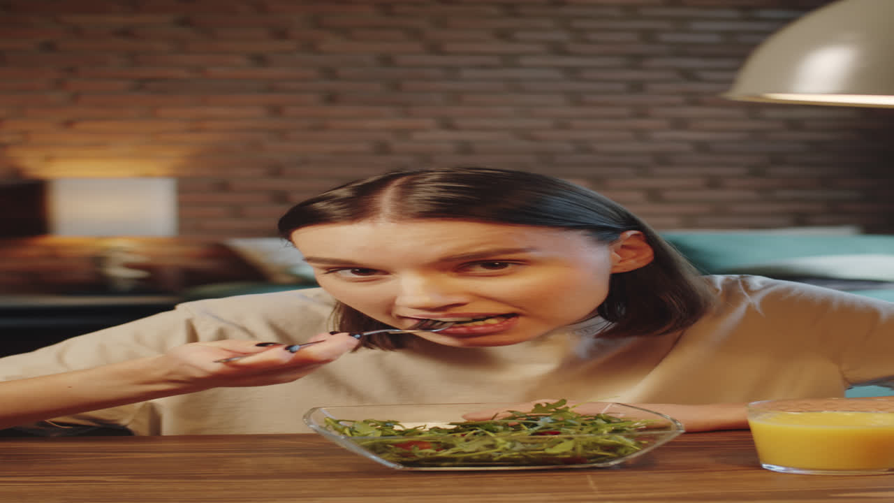 mujer joven comiendo almuerzo y hablando en una llamada web