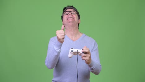 senior handsome man playing games and losing